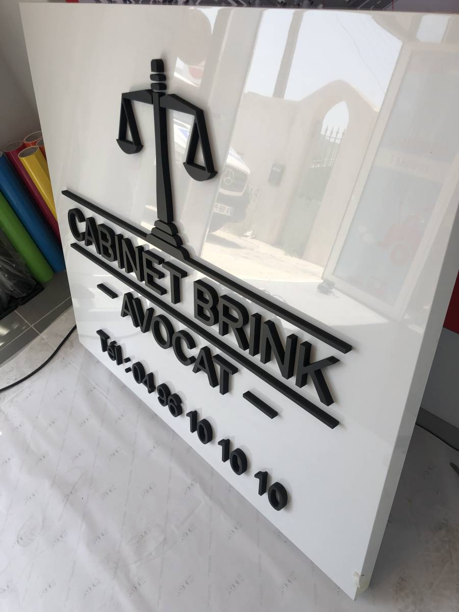 Enseigne non lumineuse caisson en tôle blanc brillant avec lettres PVC noir mat en relief.