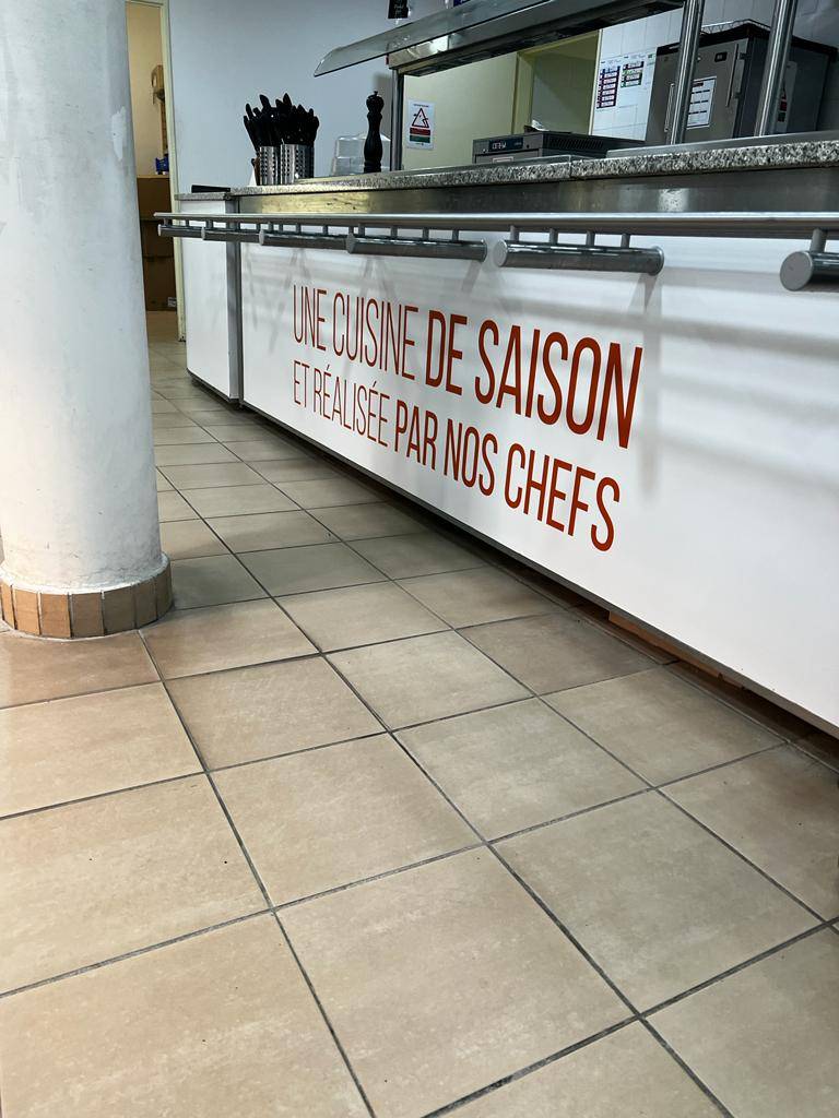 Pose de la nouvelle signalétique en lettres adhésives dans un restaurant à Marseille